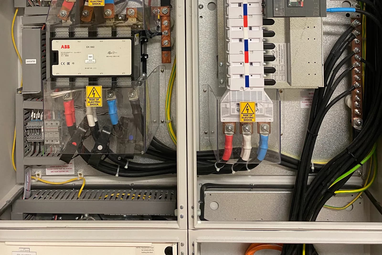 The inside of an open switchboard, with breakers, a contactor and cabling.
